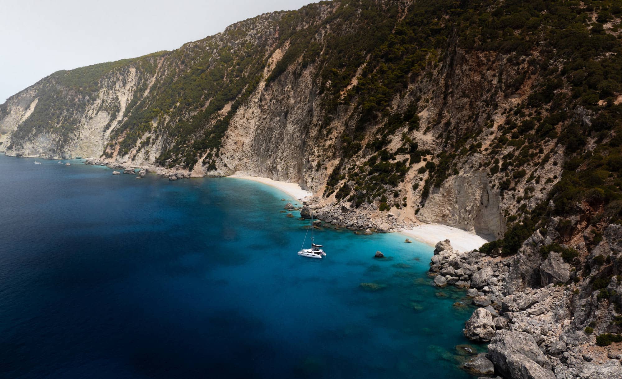 A yacht against a high cliff in Greece